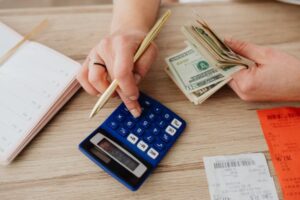 Mindful spending: Person carefully budgeting and reviewing expenses on a laptop with financial charts.